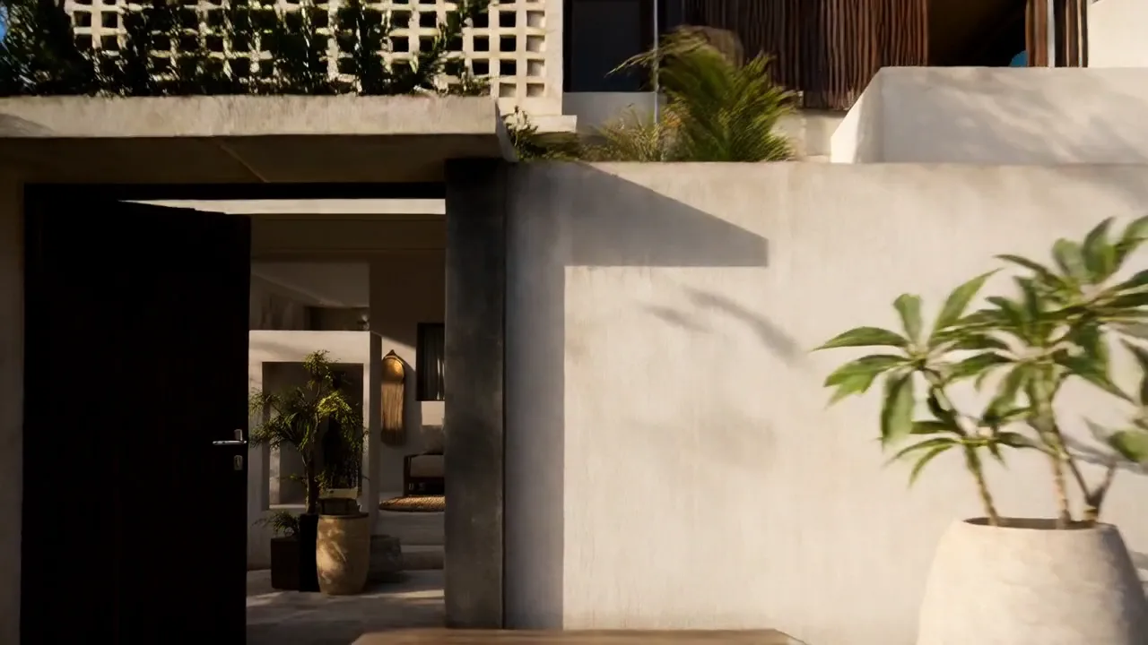 A dark timber street door stands open in a white plaster wall beneath a breeze-block screen, with potted palms in the shaded passage beyond and a frangipani in a stone pot.