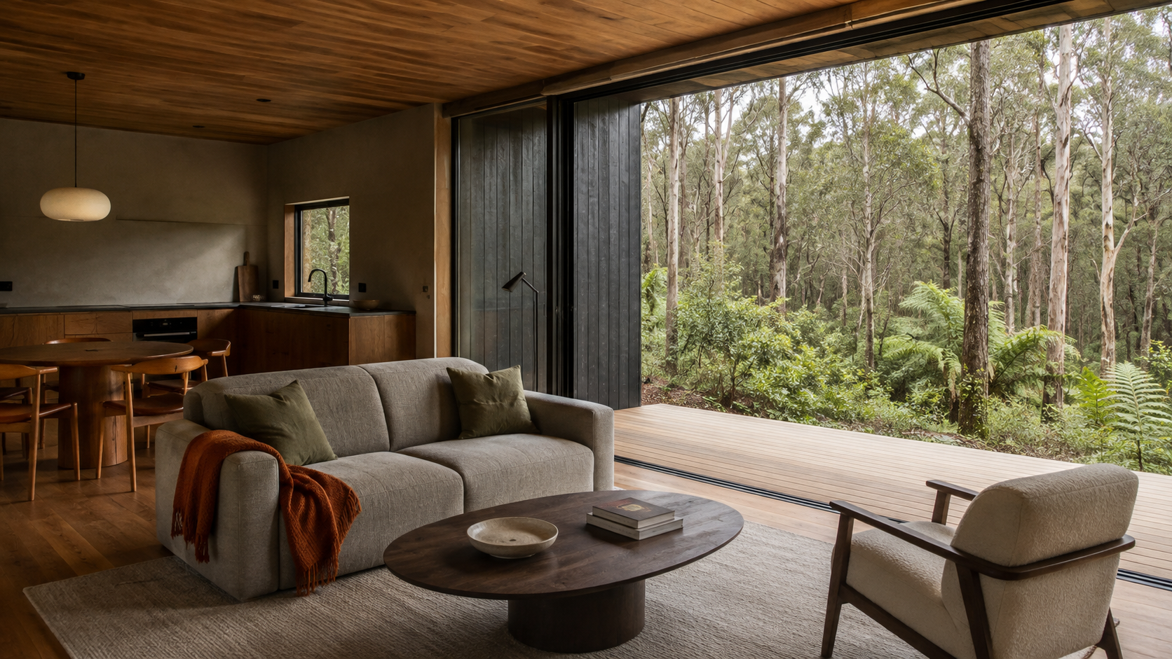AI-generated Concept living room with a grey two-seat sofa, two moss cushions, rust throw, oval timber table with bowl and two books, cream lounge chair and forest deck.