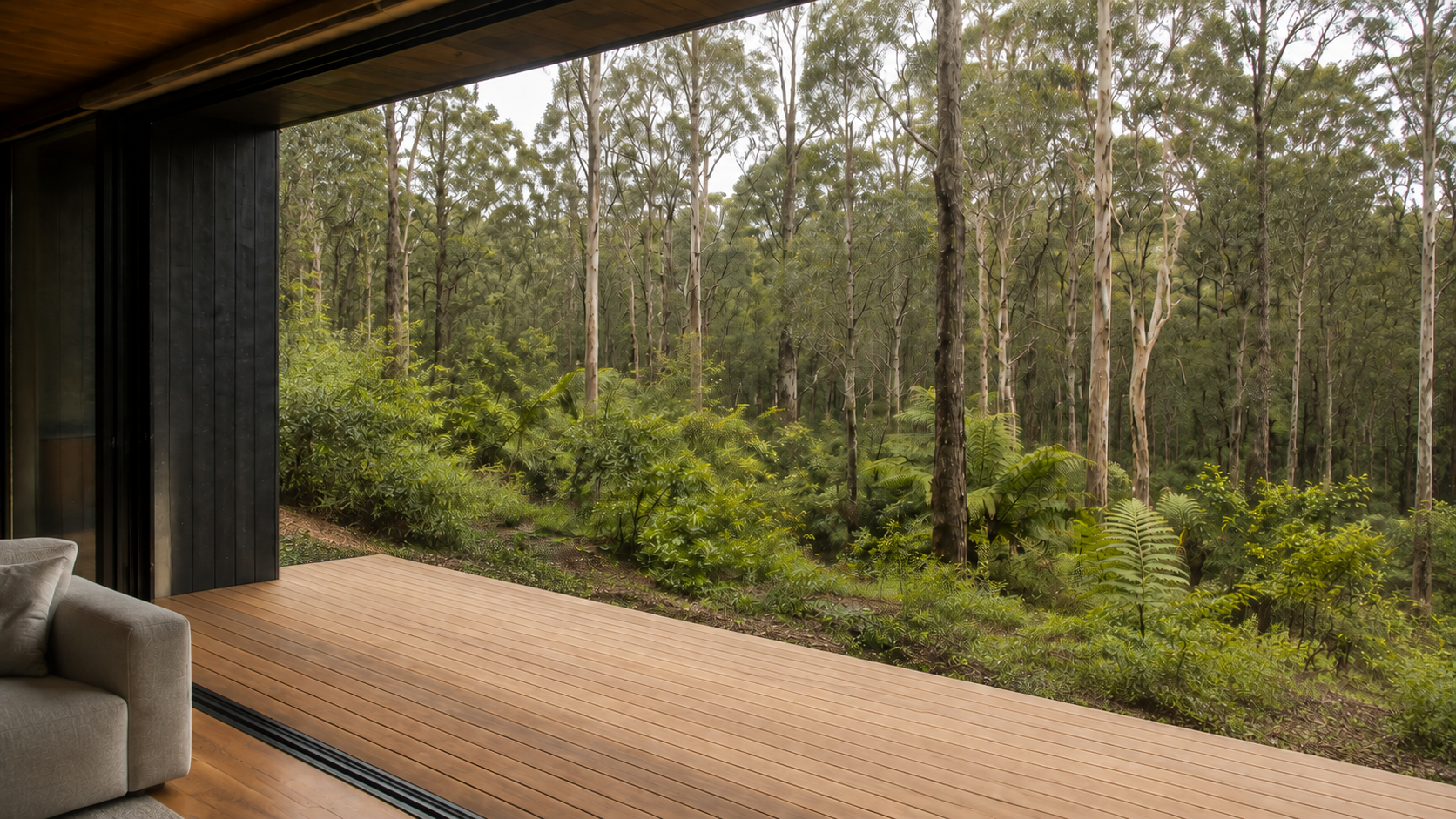 AI-generated Concept sheltered timber deck and layered forest seen through a broad threshold, with a cropped clear grey sofa arm at the left.
