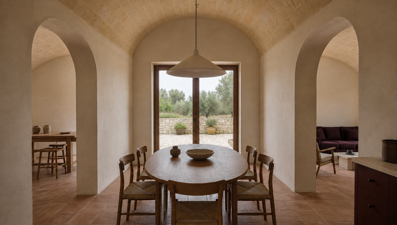Vaulted kitchen and dining room with five chairs and views through arches to the studio and living room.